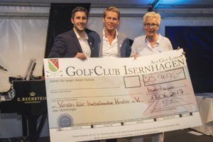 Christopher Bielke, Clubmanager des Golf Club Isernhagen, und Georgia Mysegades bei der Scheckübergabe. In der Mitte Moderator Hinnerk Baumgarten. Weitere Spenden kamen im Laufe des Abends hinzu.